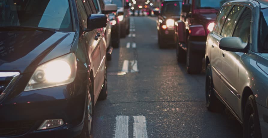 cars sitting in a traffic jam with lights on