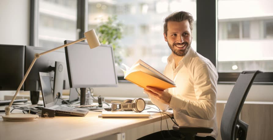 man in an office smiling at his desk