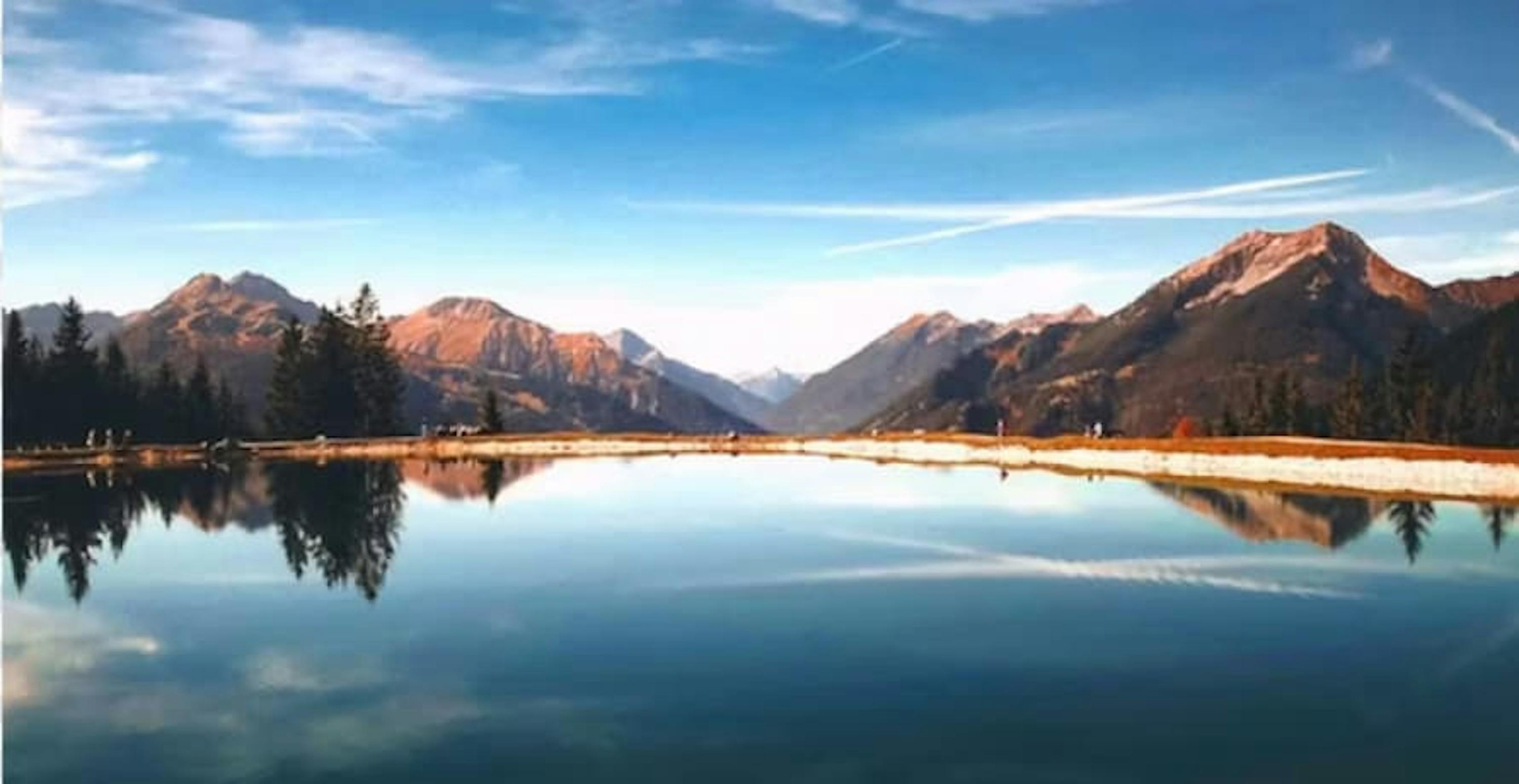 lake view with blue sky and red mountains