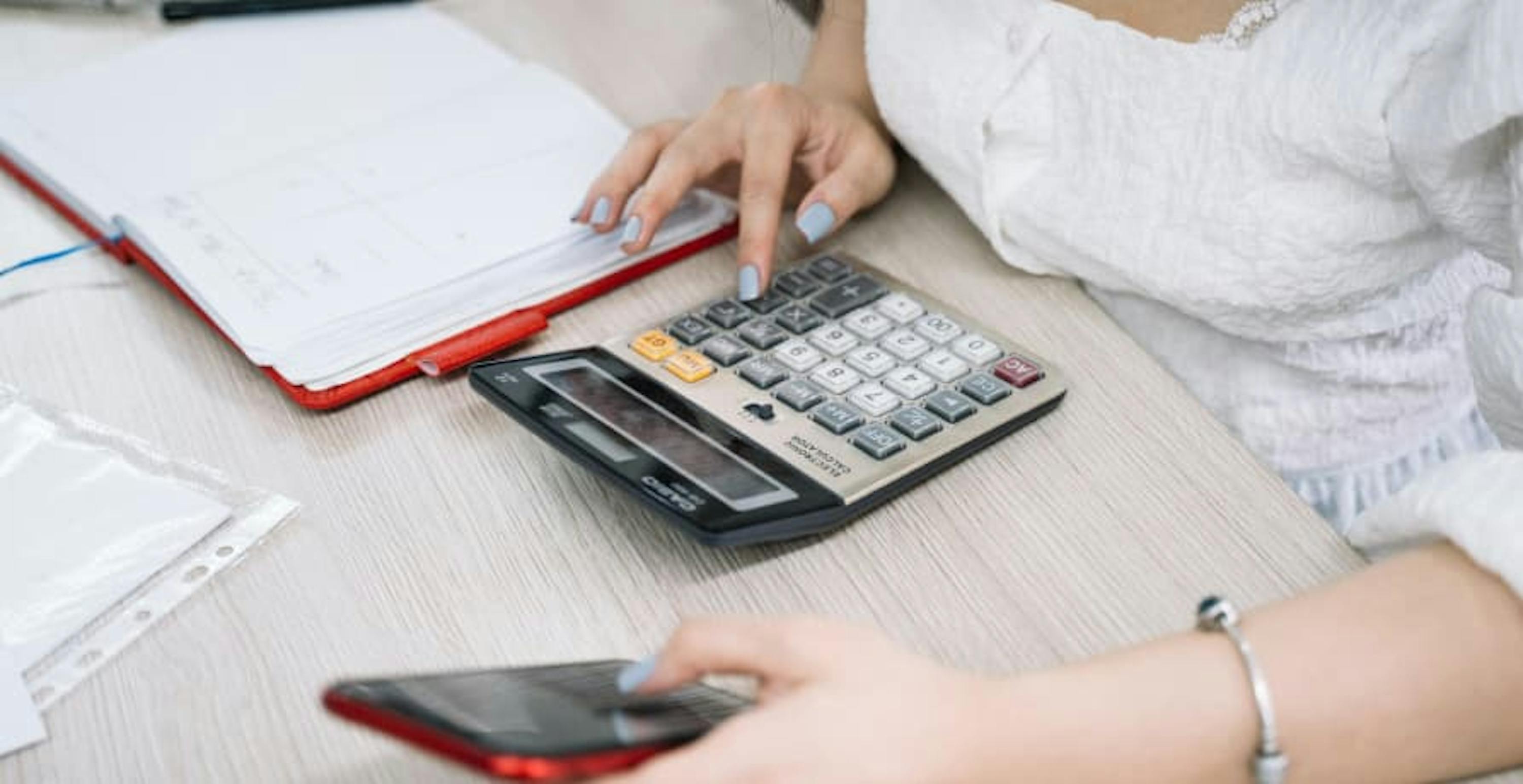 woman working on a calculator at a desk