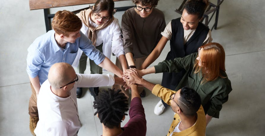 eight employees standing in a circle giving a high five