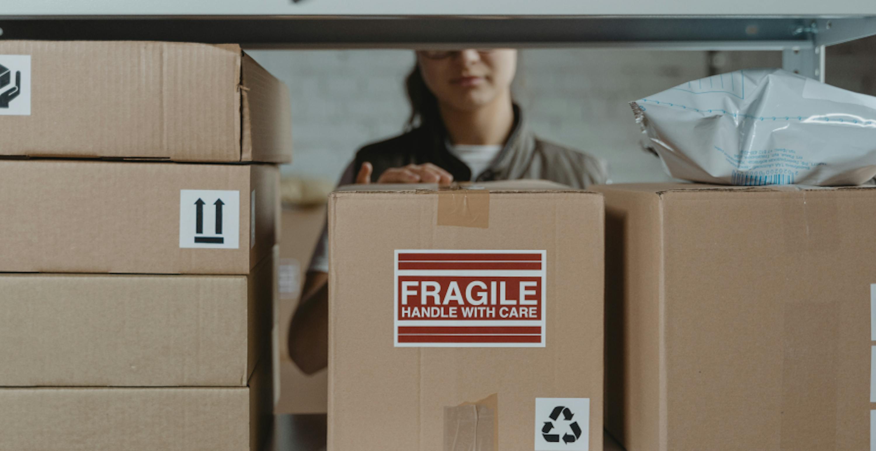 woman in warehouse with fragile box