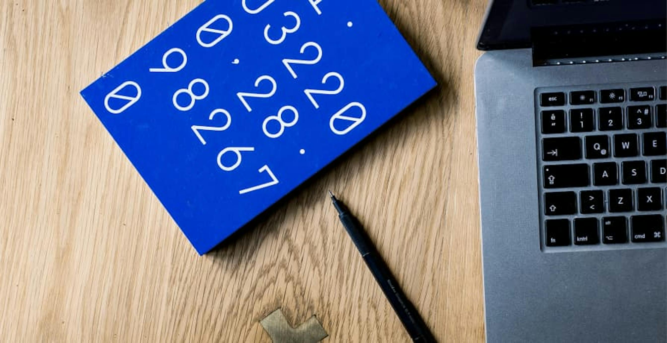 numbers next to laptop with pen