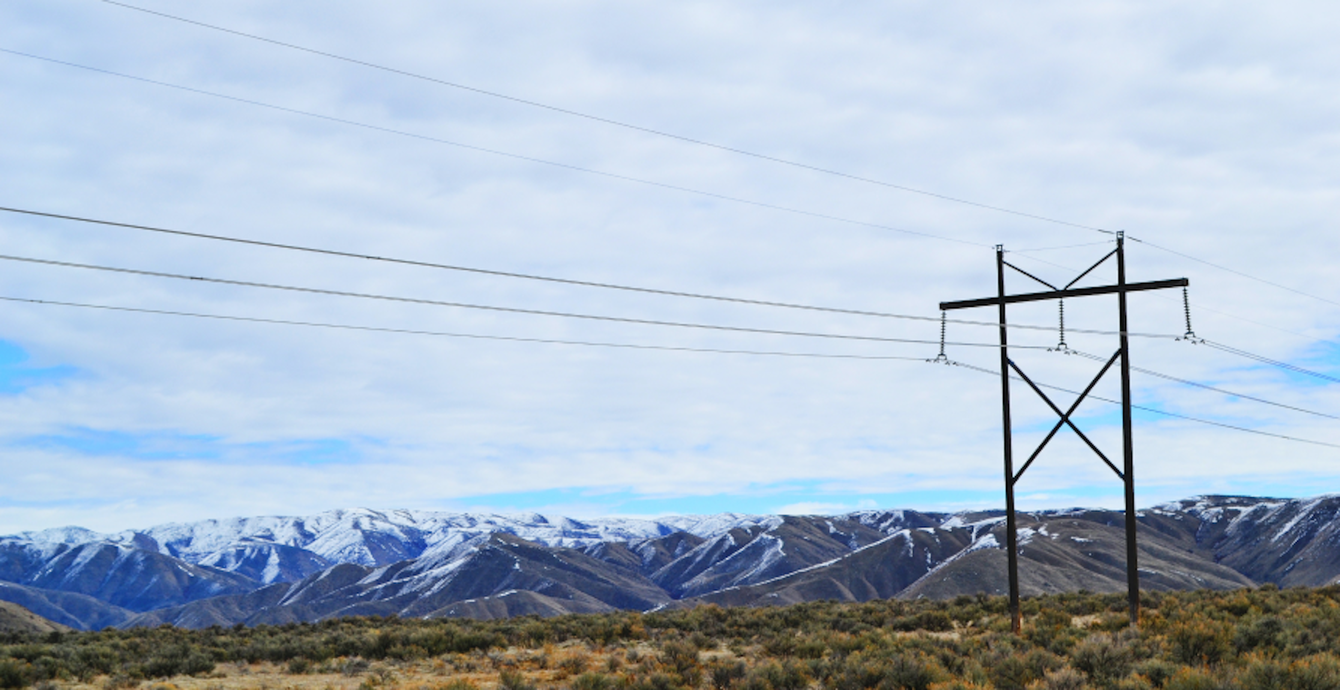 cold landscape with snow tipped hills in the distance