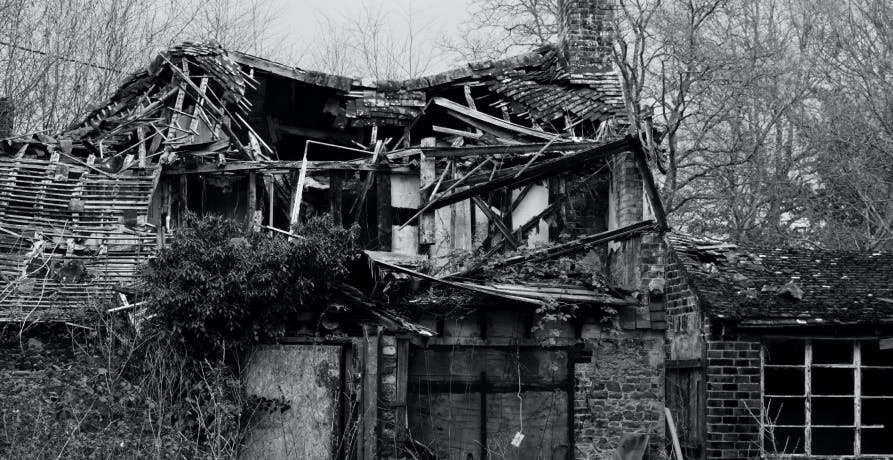 photo en noir et blanc d'une maison effondrée
