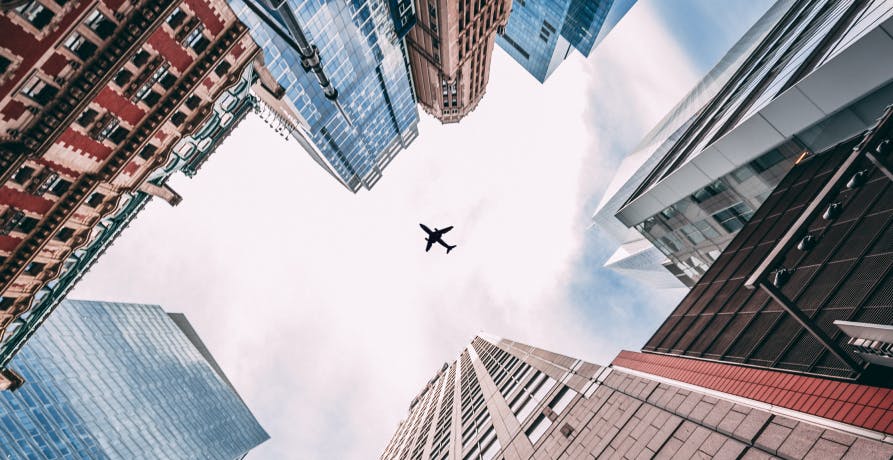 un avion qui survole les immeubles de New-York