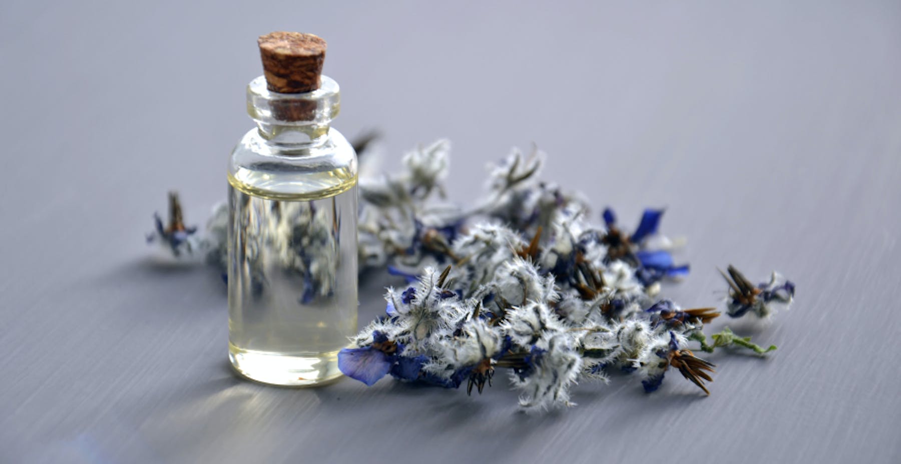 perfume surrounded by small purple flowers
