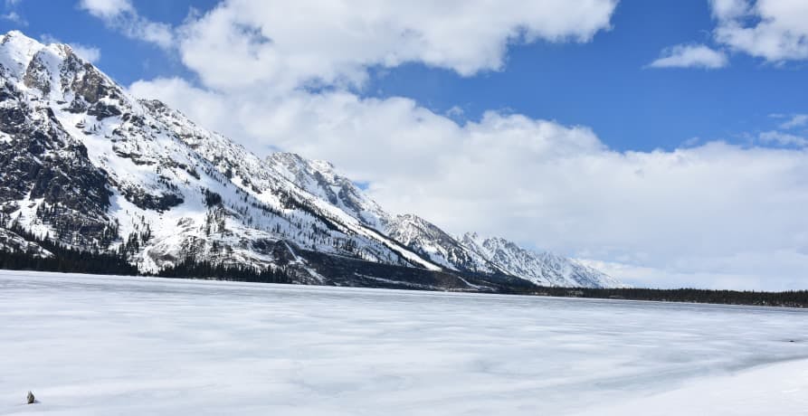 snowy mountain under blue cloudy sky