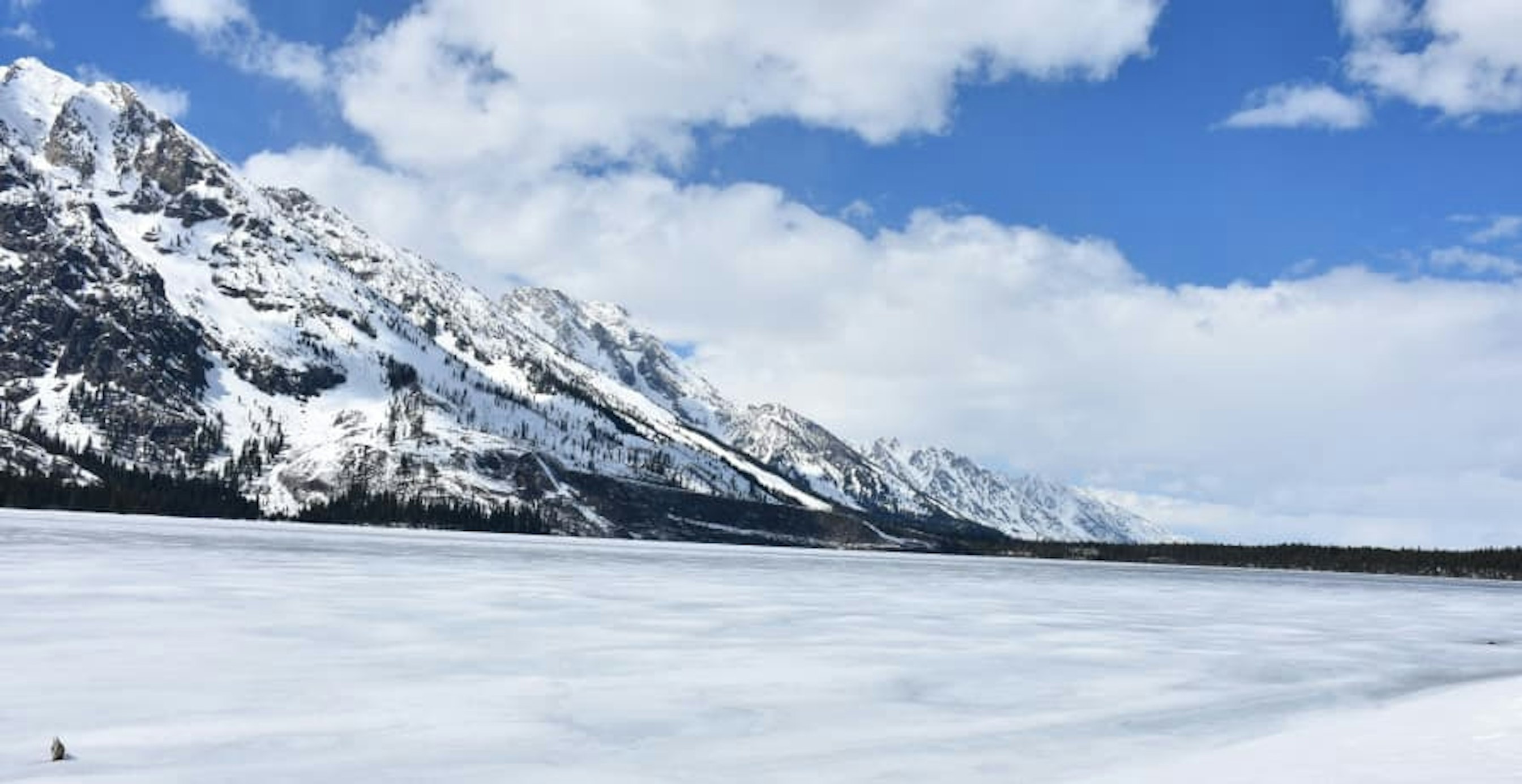 snowy mountain under blue cloudy sky