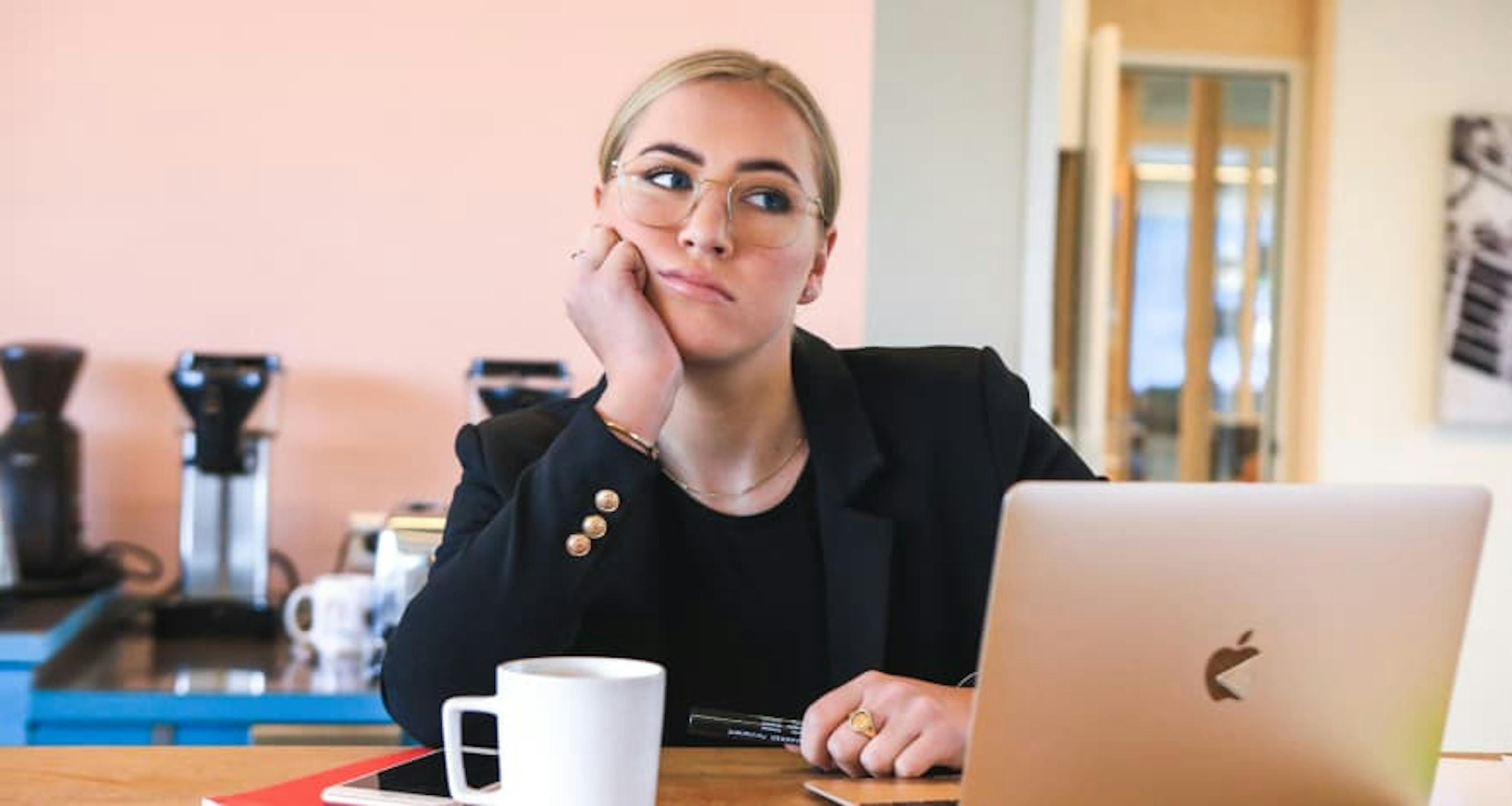 young unsatisfied employee behind macbook