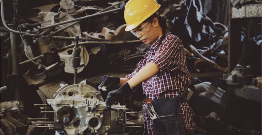 woman wearing yellow hard hat working on car parts