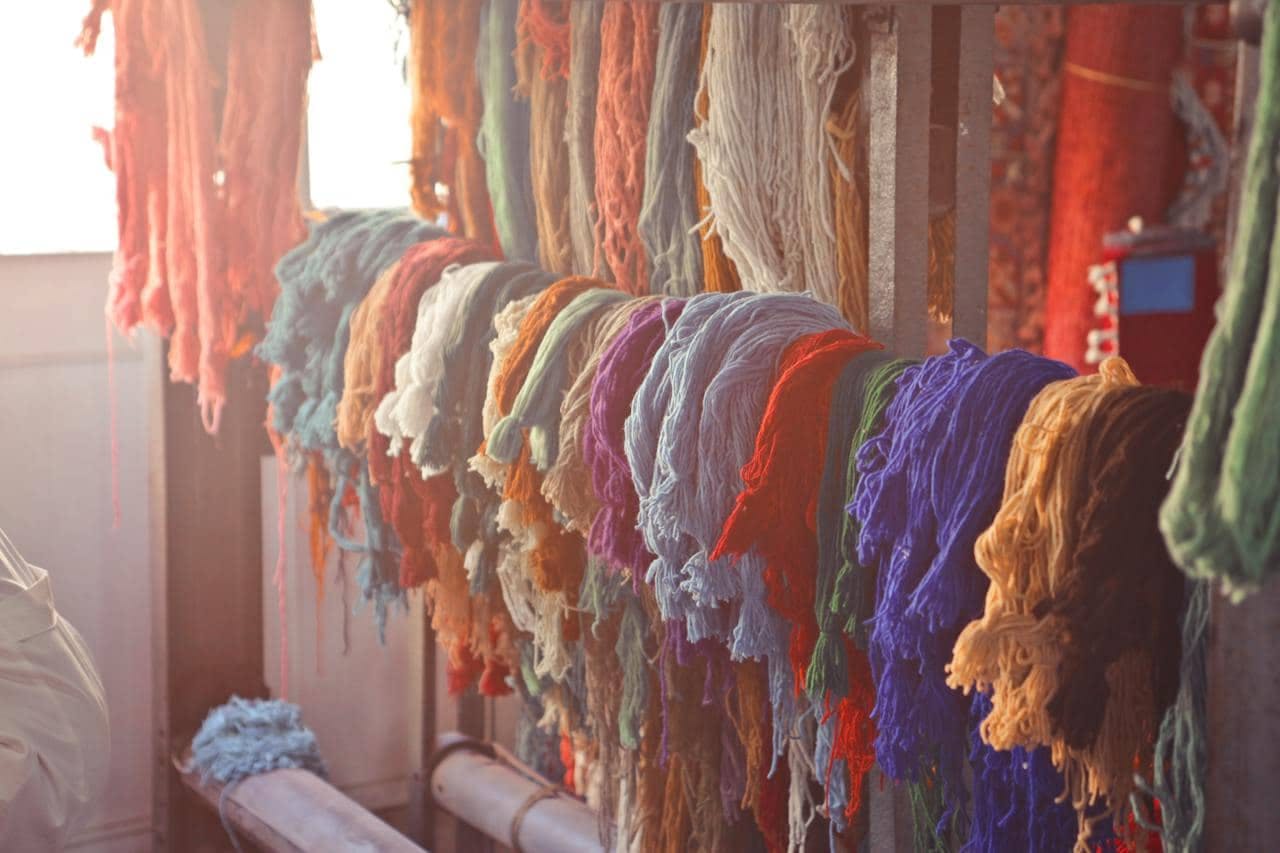 Various colorful threads hanging on rail in workshop