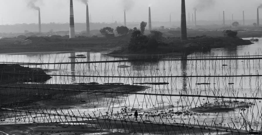 Image of polluted landscape with factories that are releasing carbon dioxide into the air