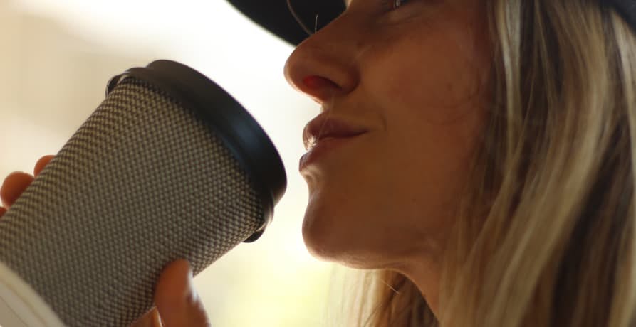 woman holding a disposable coffee cup to her mouth