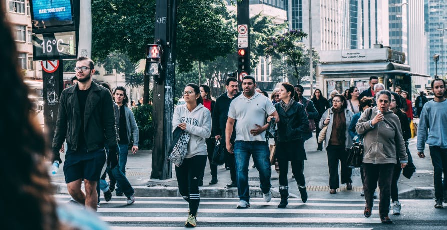 pedestrians walking across a road in a city centre