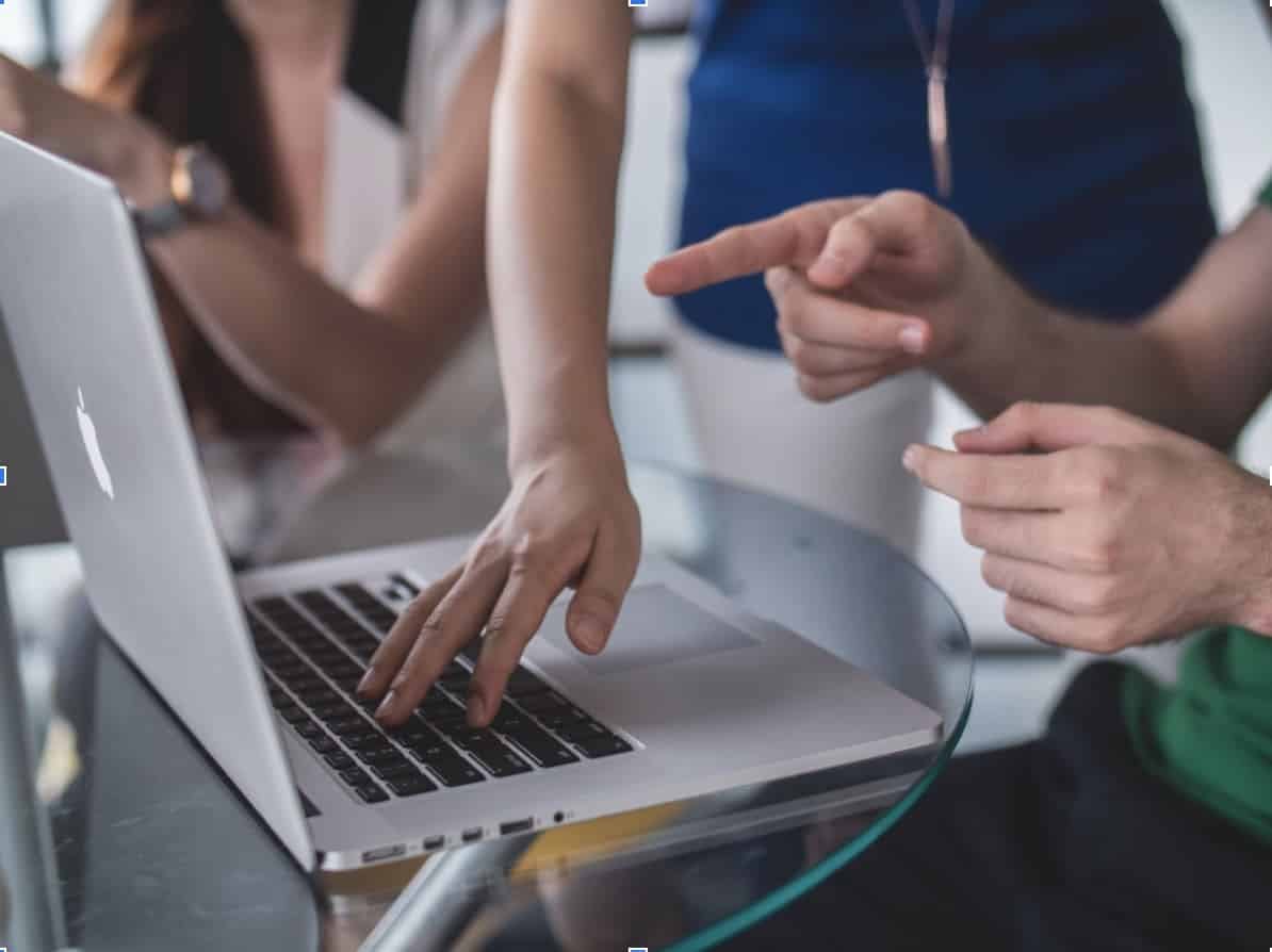 personnes pointant vers un ordinateur portable