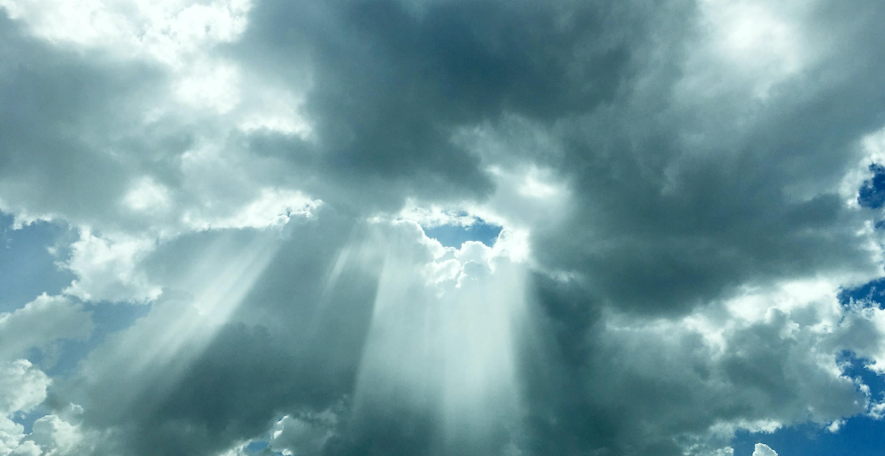 ciel couvert de nuages gris avec rayons de soleil