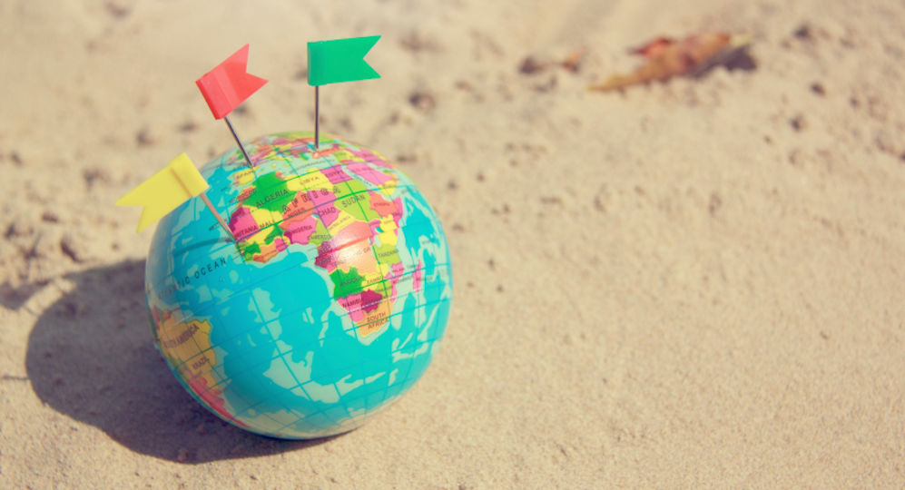 earth with little flags in sand