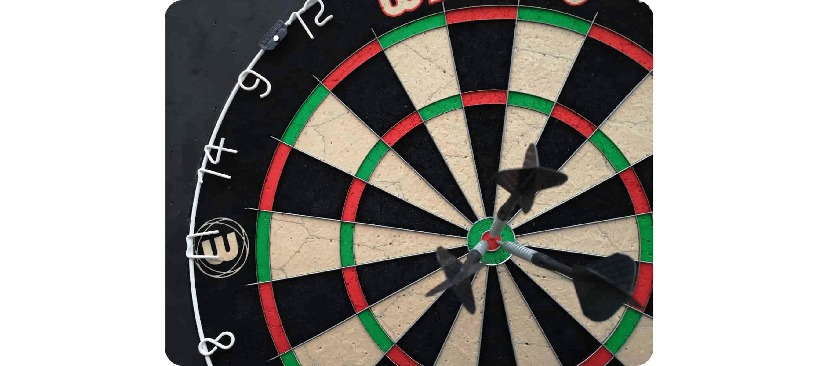 A close-up shot of a dartboard with darts on the bullseye