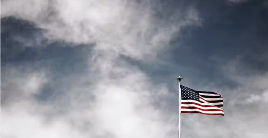 us flag in cloudy muted sky