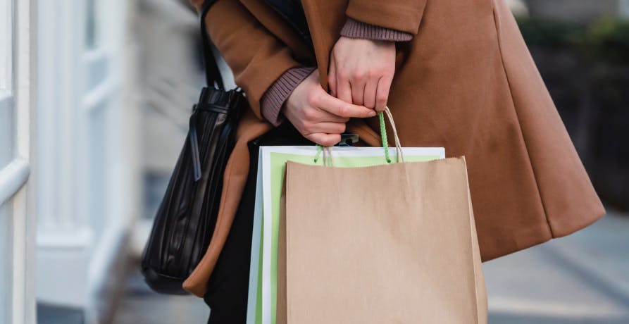 une femme tenant des sacs de shopping dans les mains