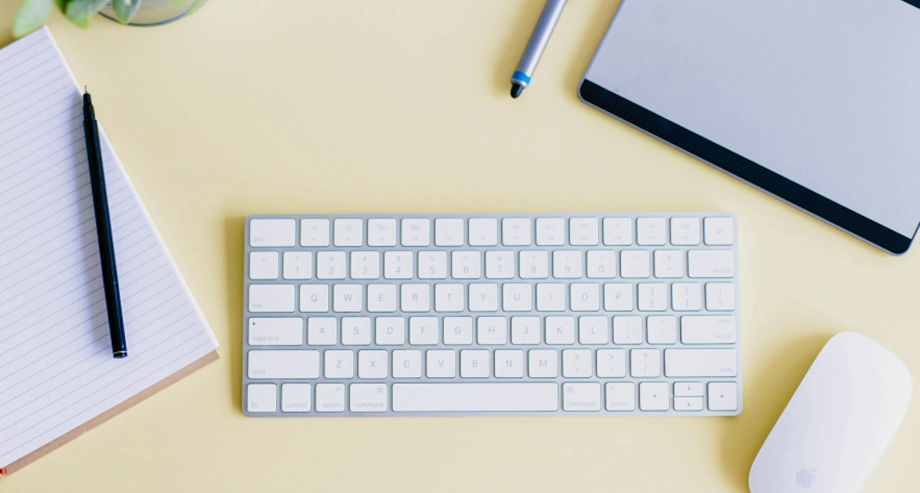 un clavier, une souris, un bloc notes et un stylo