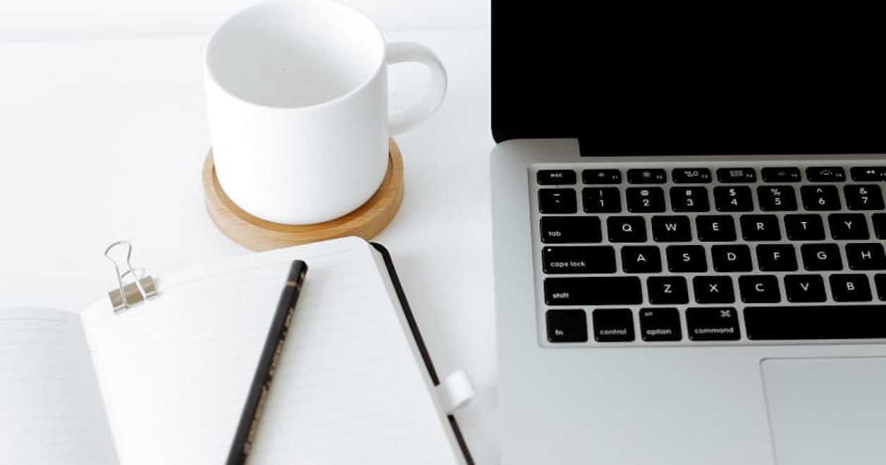 laptop next to coffee cup