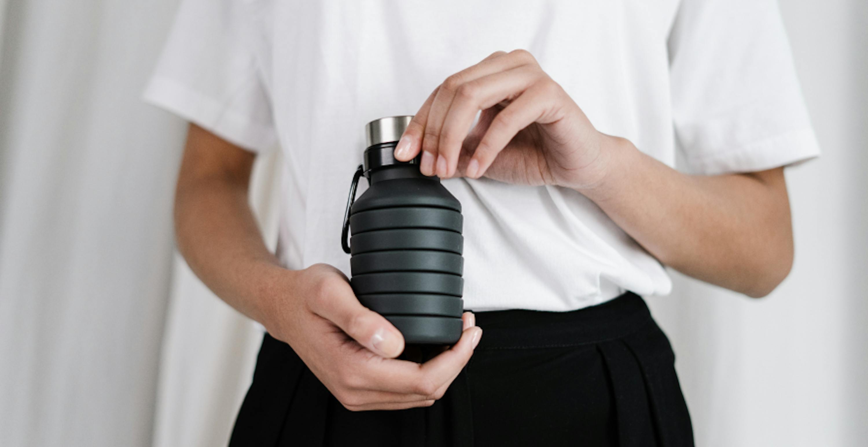 person holding reusable water bottle 