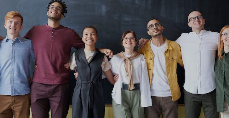 people standing in front of a chalkboard smiling