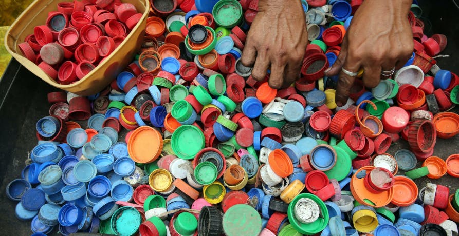 person sorting through plastic bottle caps