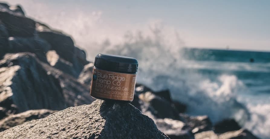 tub of product sitting on cliff with ocean waves behind it