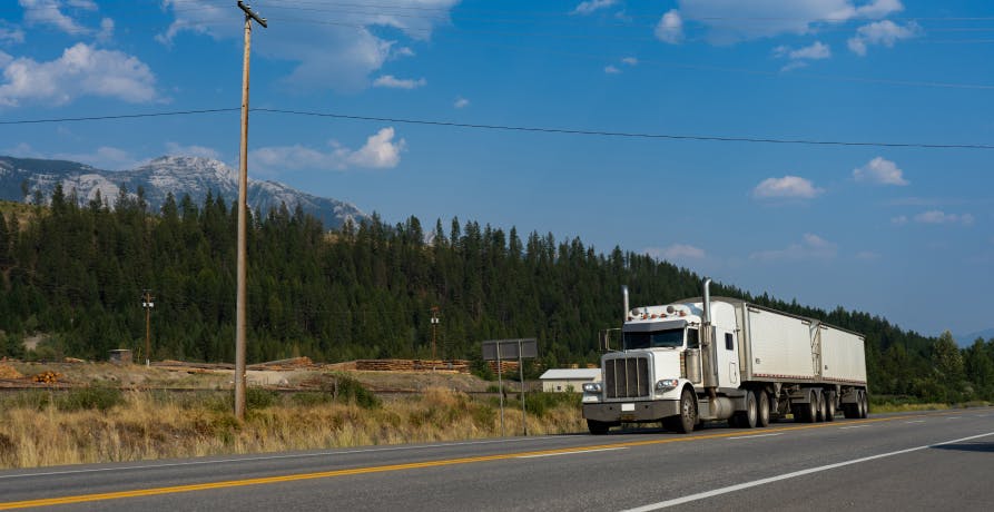 large truck driving on road in the countryside