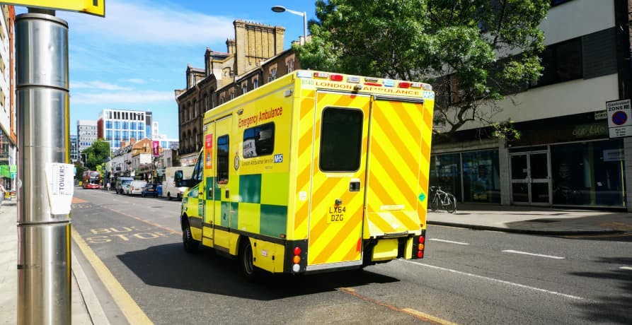 NHS ambulance driving down a city street