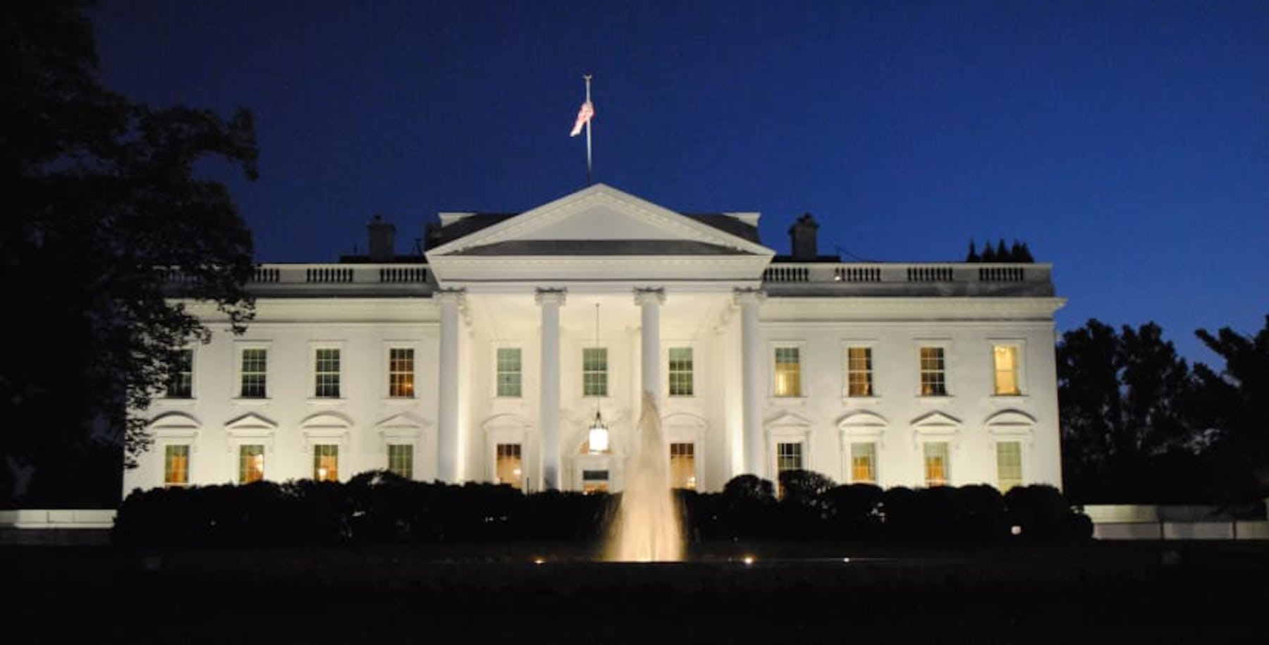 white house lit up at night navy blue sky