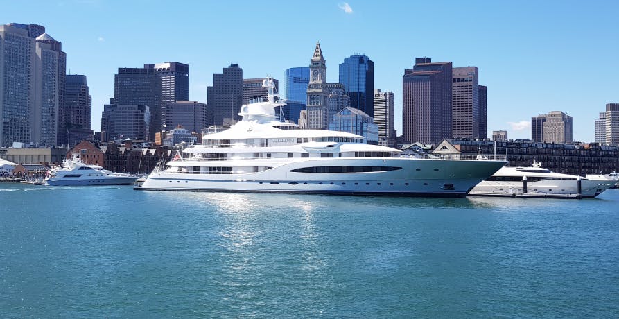 boat in boston on water with skyline behind it