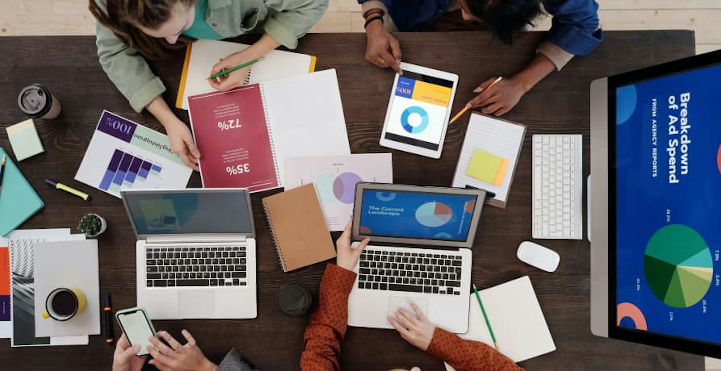 people working at a desk, looking over reports 