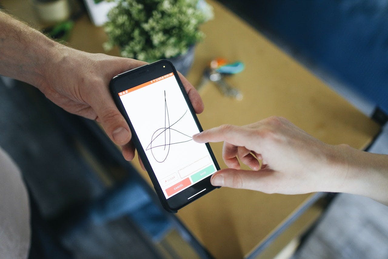 personne signant sur l'écran du téléphone