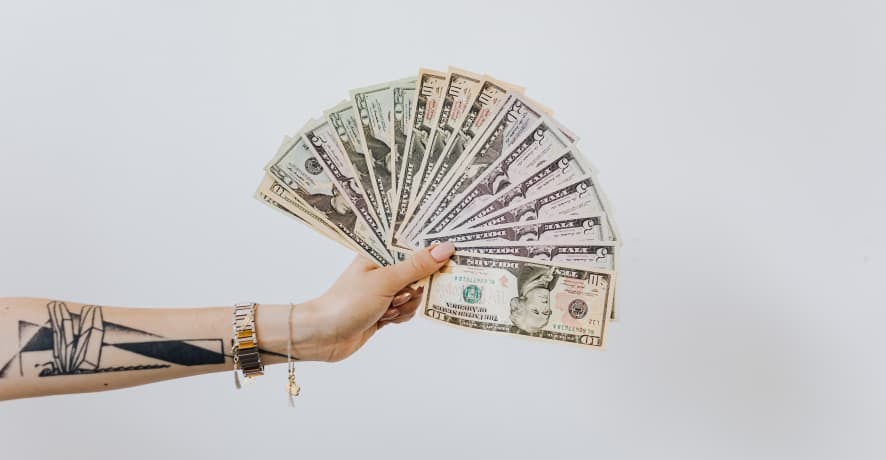 person holding USD dollar bills like a fan