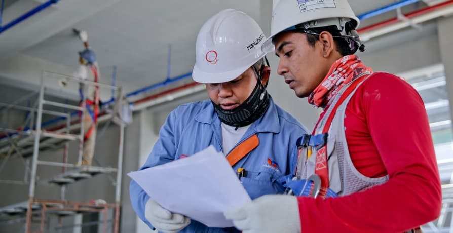 construction workers looking over paper