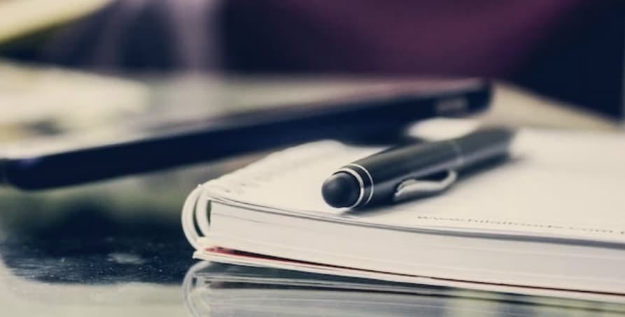 a notebook and a pen on a table