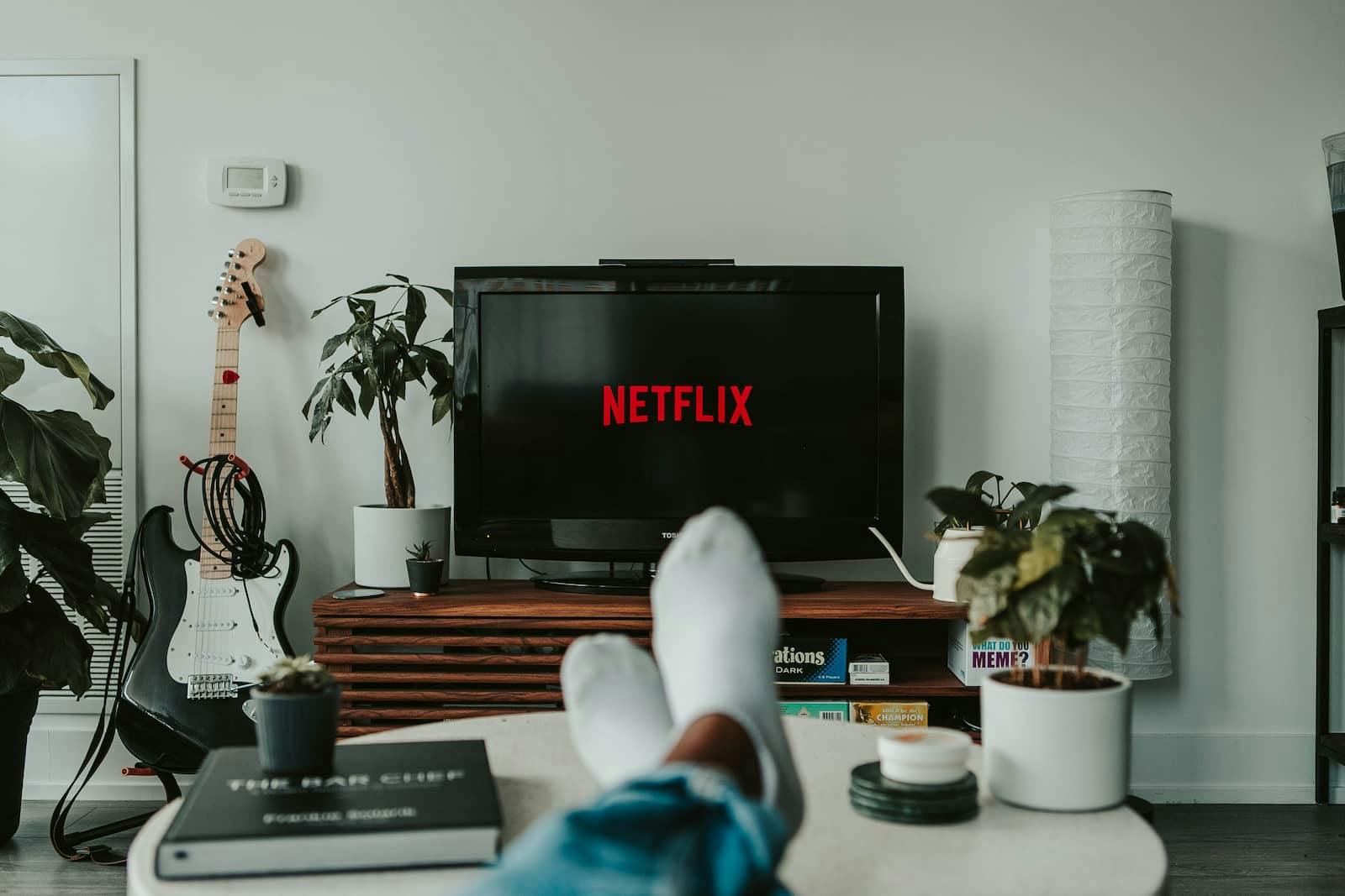 Personne devant un écran avec écrit "Netflix"