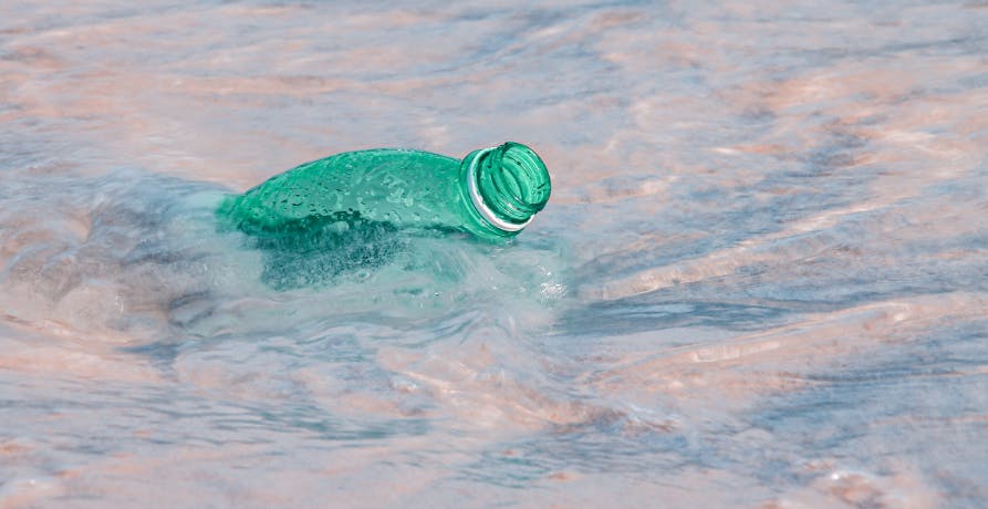 bouteille en plastique verte flottant dans l'eau