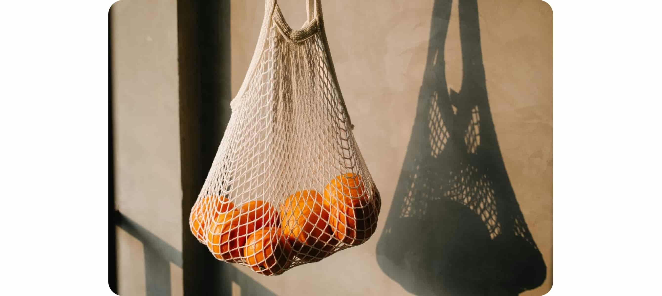 des oranges dans un sac à ficelle blanc