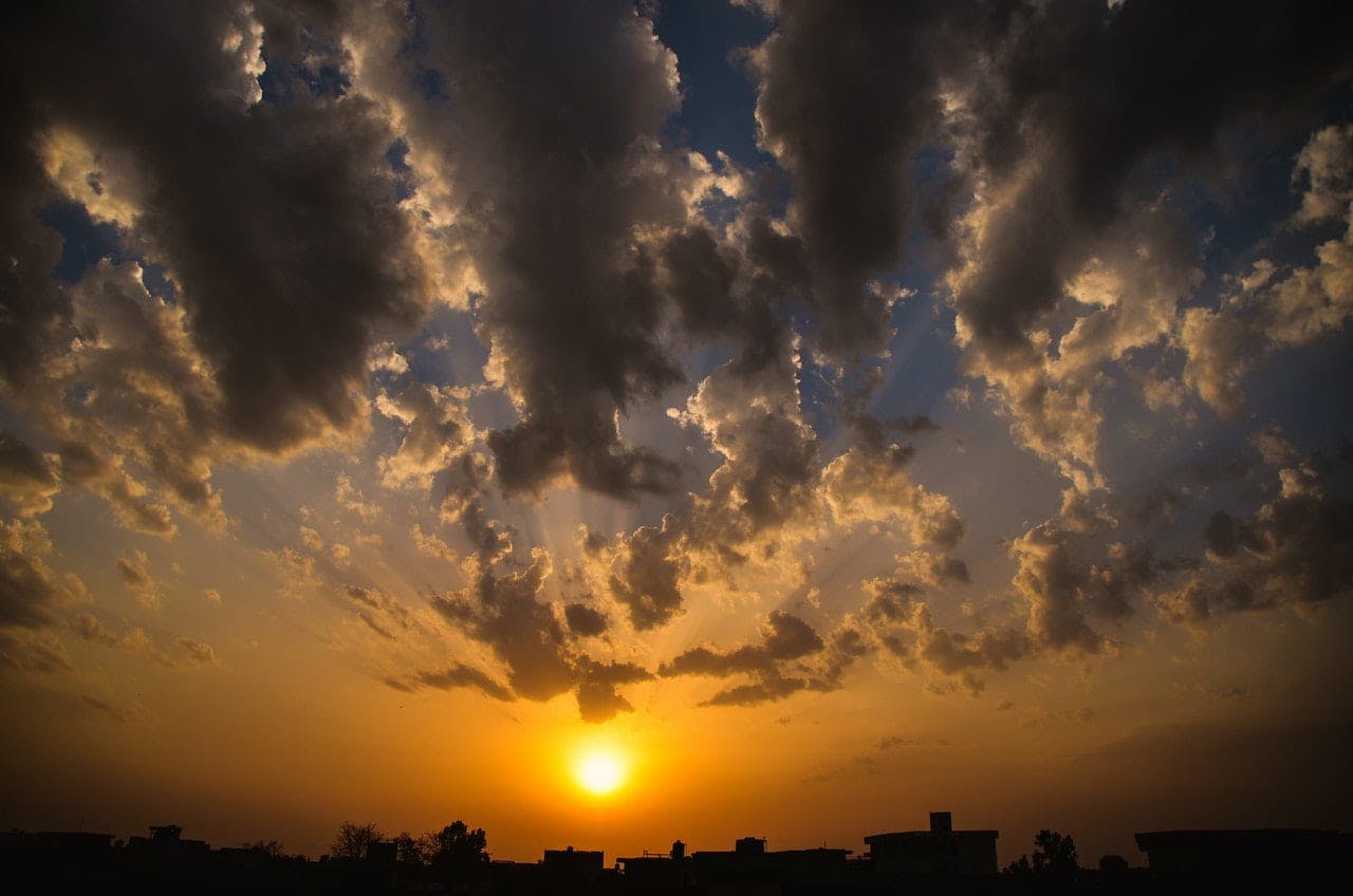 Silhouette de bâtiments sous un ciel nuageux