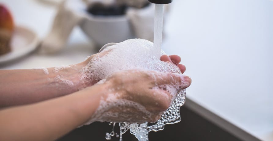 person washing hands in the sink