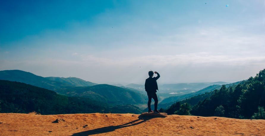 person hiking overlooking mountains