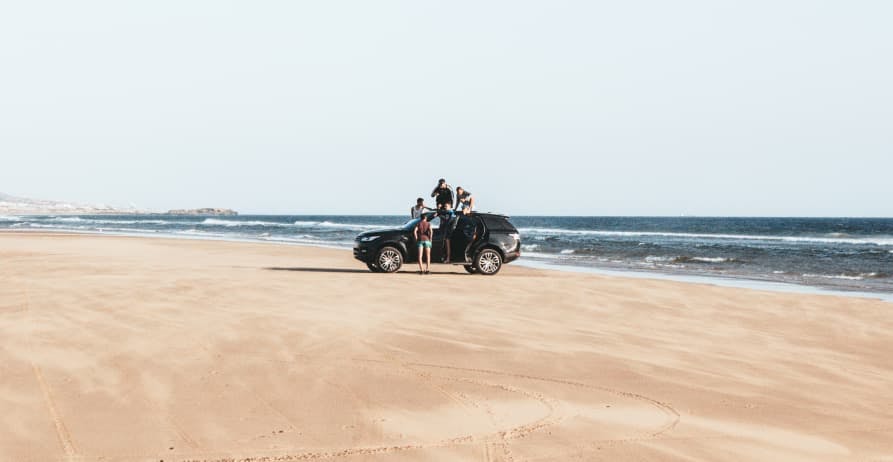 people on road trip at the beach