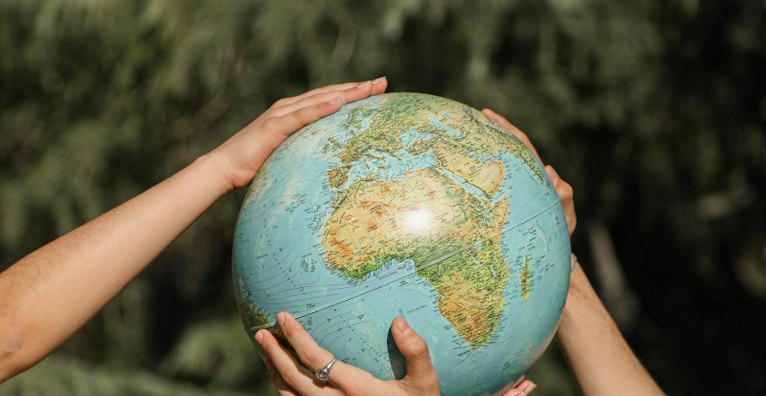 two people holding globe