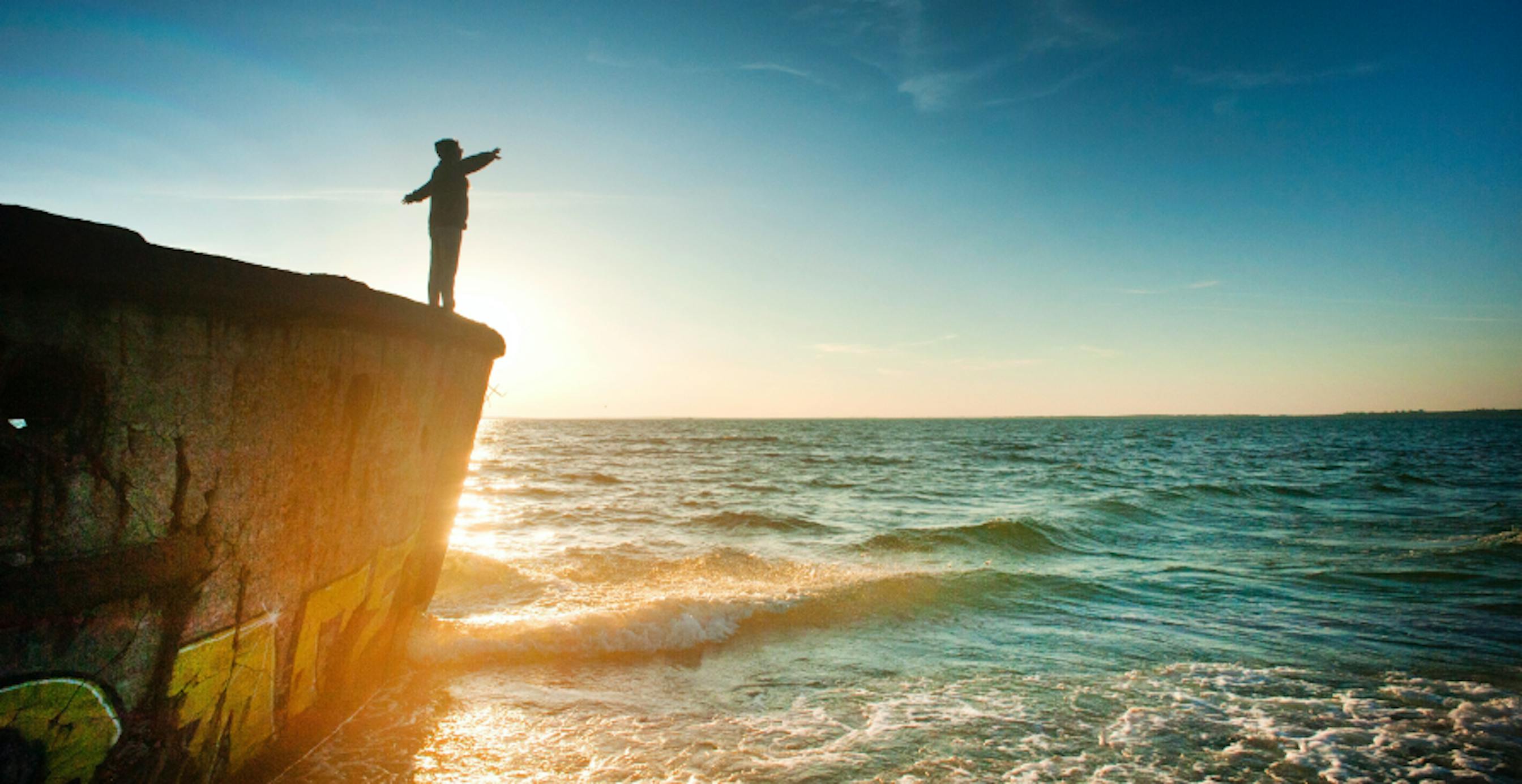 person standing over a cliff over water