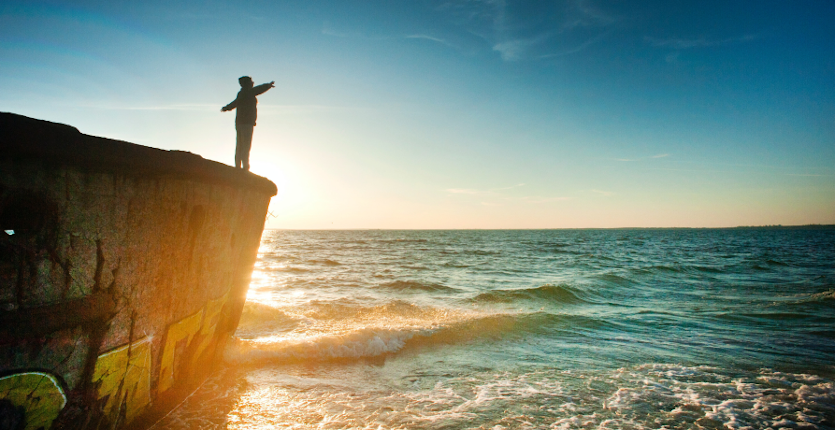 person standing over a cliff over water